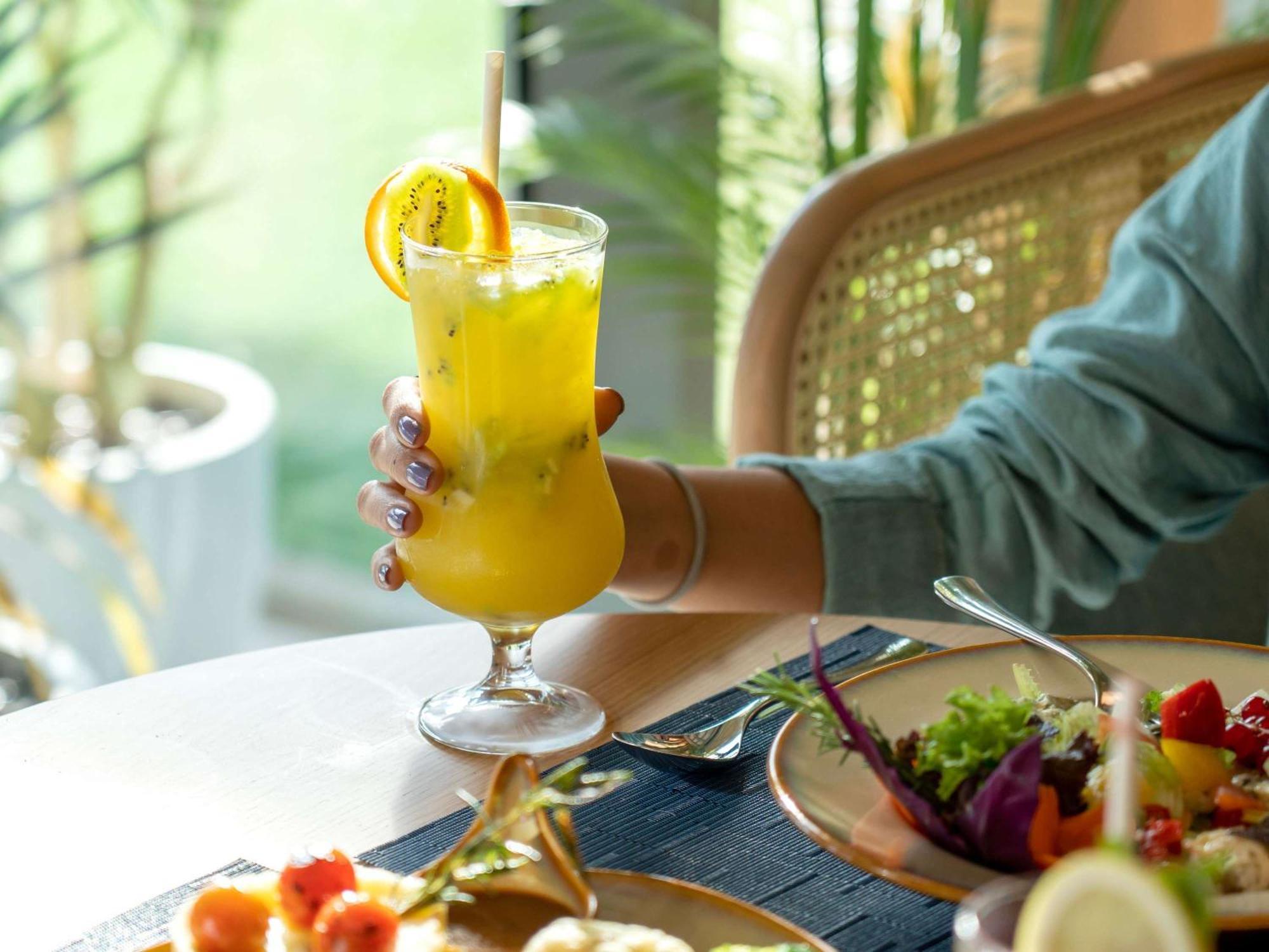 Swissotel Living Dzsidda Kültér fotó A woman holding a glass of juice